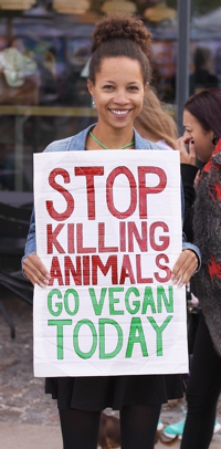 Vegan holding sign in protest of killing animals