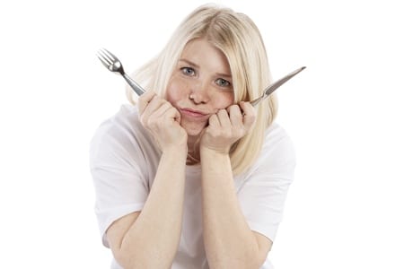 Hungry woman with fork & knife