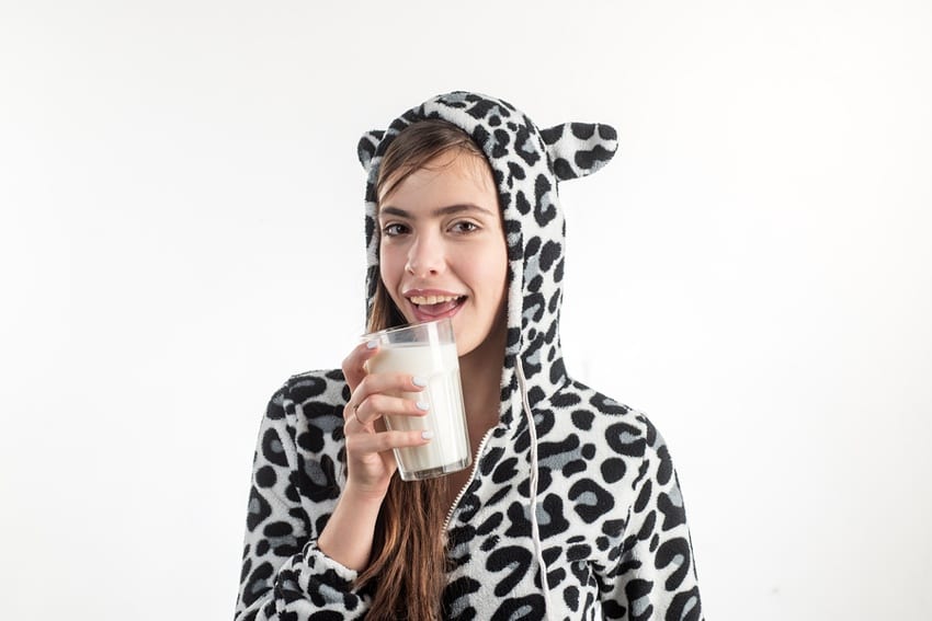 Woman drinking milk dressed like a cow