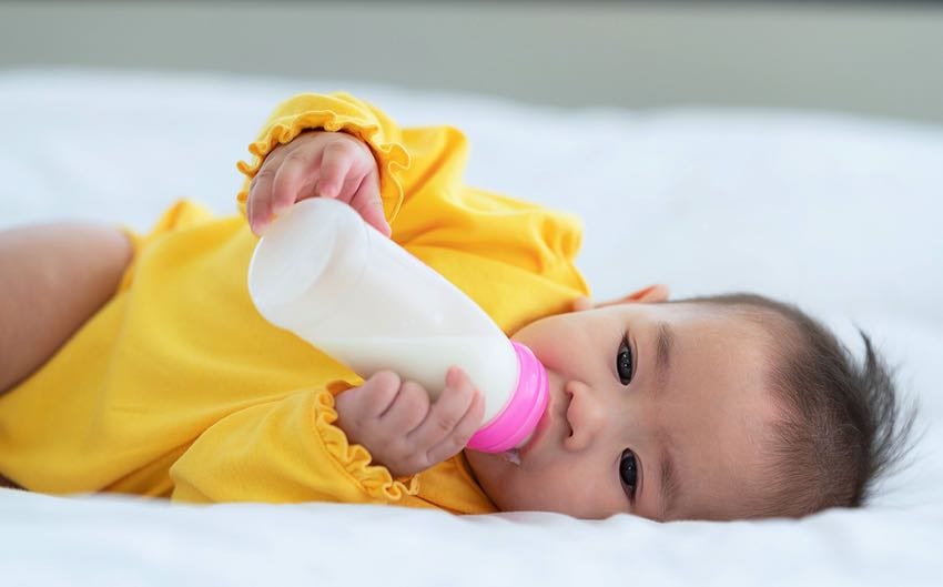 Cute baby drinking formula from a bottle