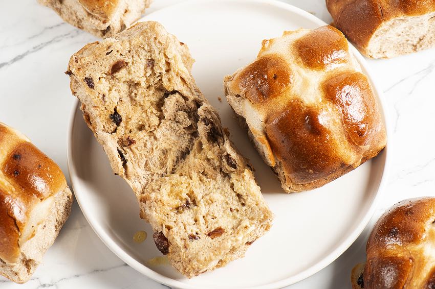 Hot crossed buns on a plate sliced open