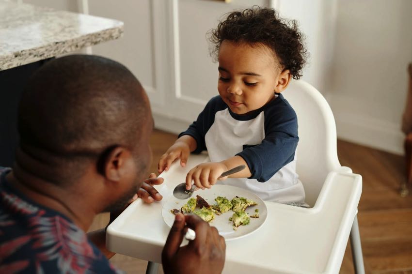 Kid eating breakfast with parent